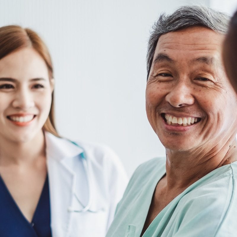 smiling asian patient with nurses