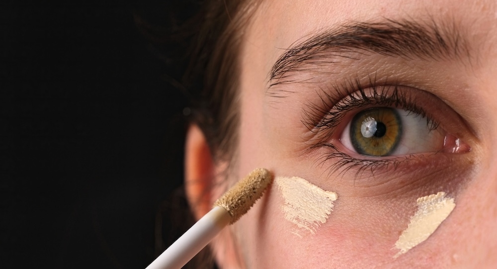 Close-Up Shot Of A Girl Applying Concealer Under Her Eyes