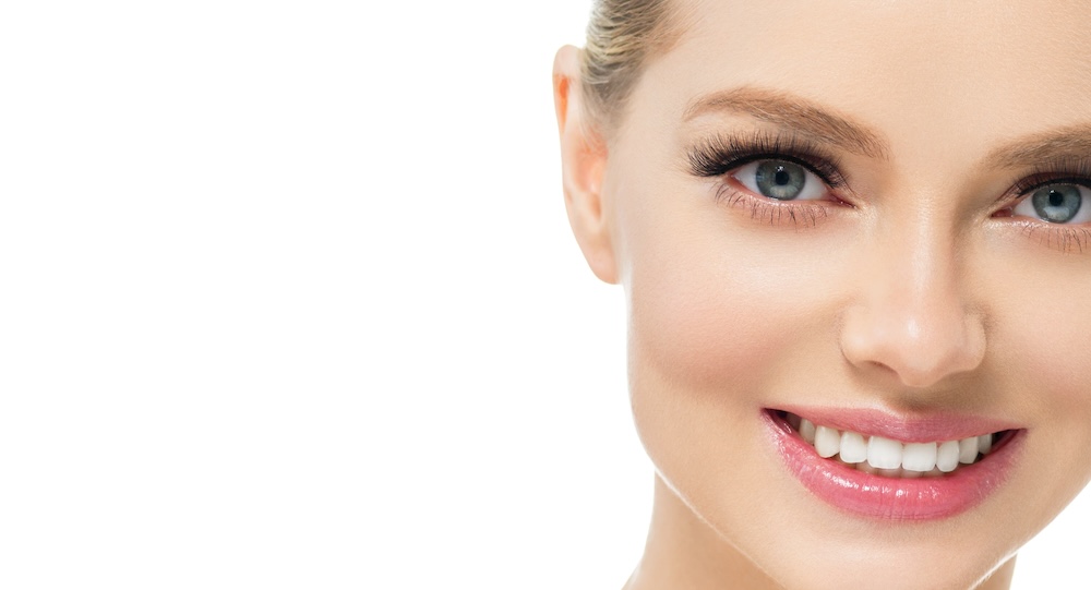 Woman smiling closeup with white background.