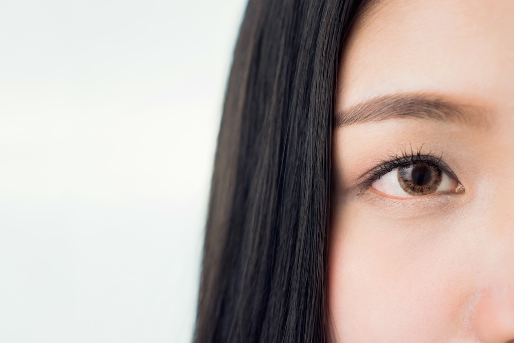 The face and eye of a woman with good skin health and pink lips