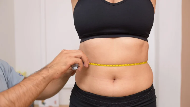 how to get rid of belly fat - doctor measuring the belly area of a female