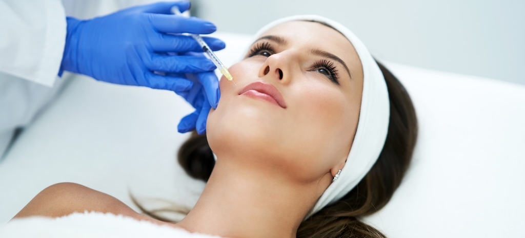 beautiful young woman getting fillers in clinic