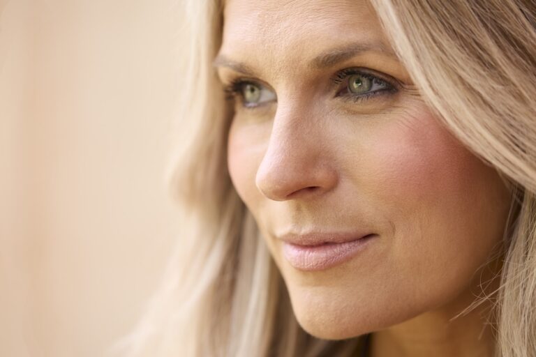 Close Up Beauty Portrait Of Smiling Mature Woman Against Natural Background