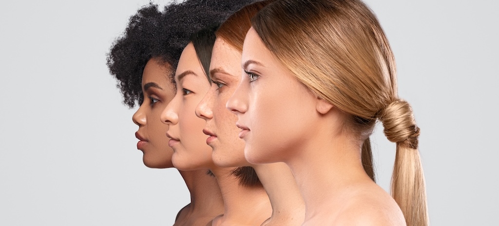 Side view of attractive diverse ladies standing in line while representing spa industry against gray background